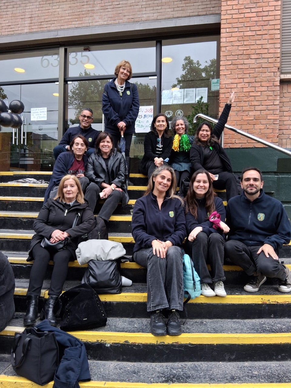 Trabajadores reunidos en las escaleras del colegio