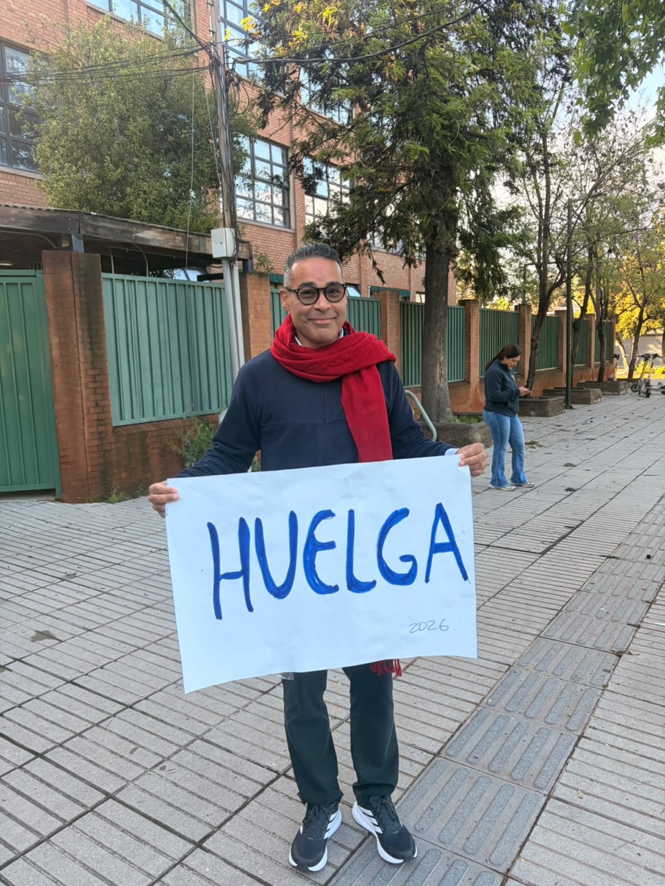 Cartel de huelga y bufanda roja frente al colegio