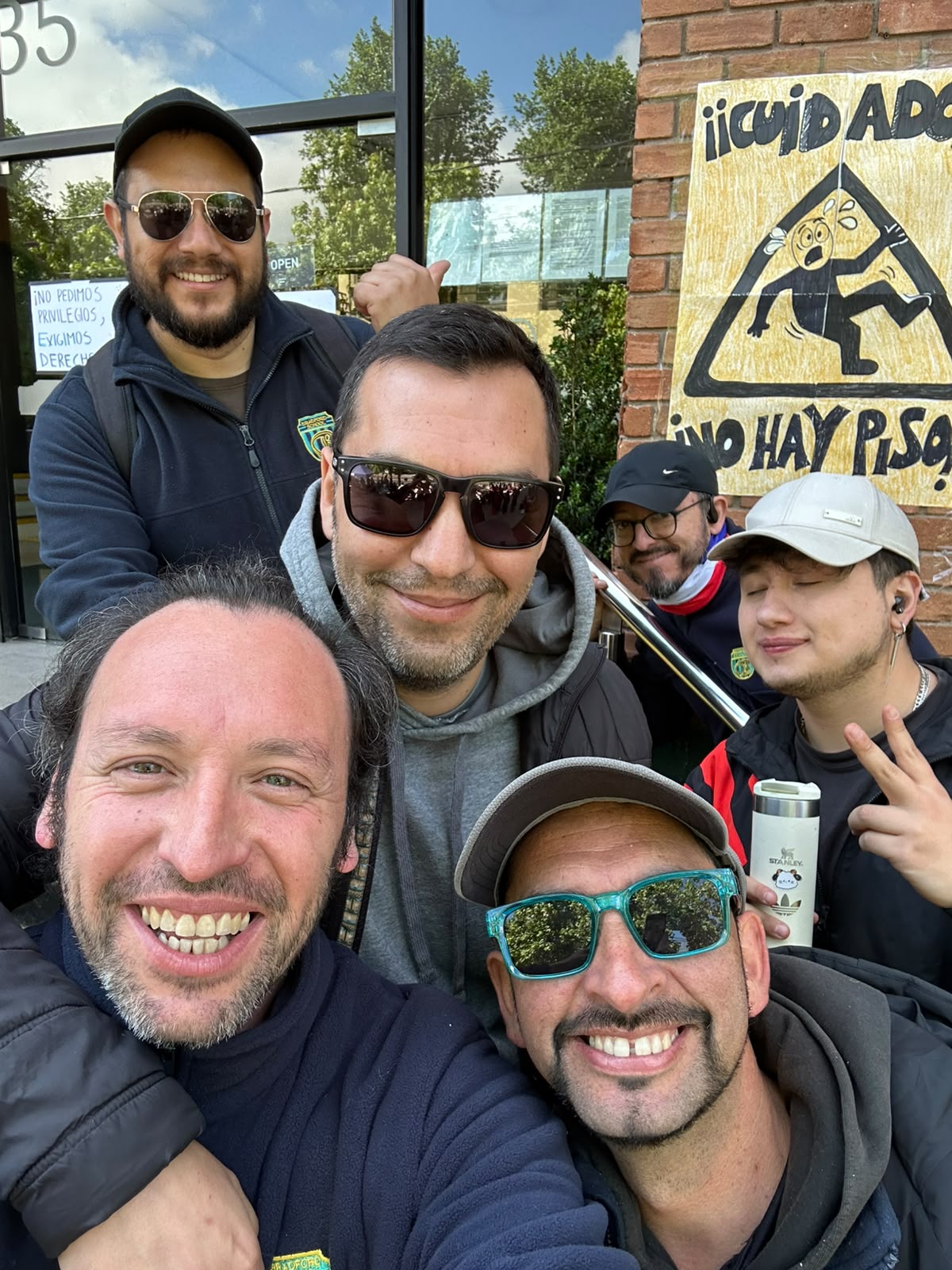 Compañeros junto al cartel de la movilización
