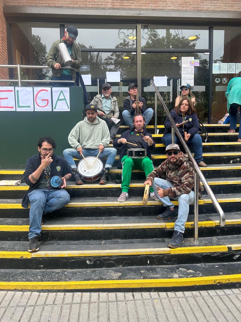Compañeros reunidos con instrumentos en las escaleras del colegio